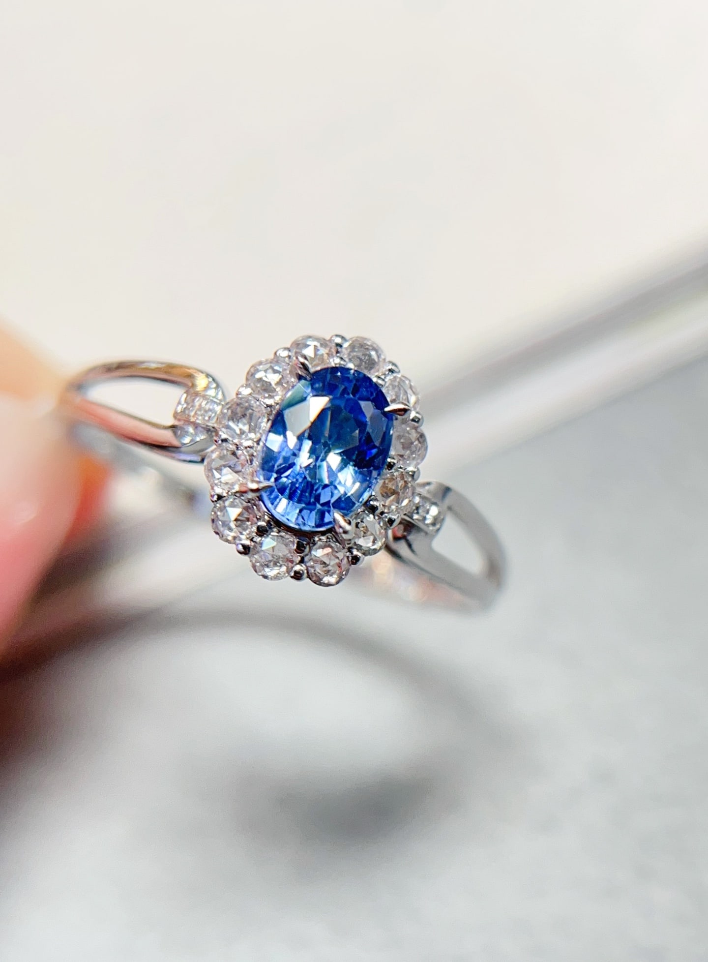 18K Gold Sapphire Ring: This ring is crafted from 18K gold, featuring an approximately 0.6-carat sapphire that exudes a cornflower-like elegant hue. Complemented by four diamonds and twelve white sapphires, the design is bri