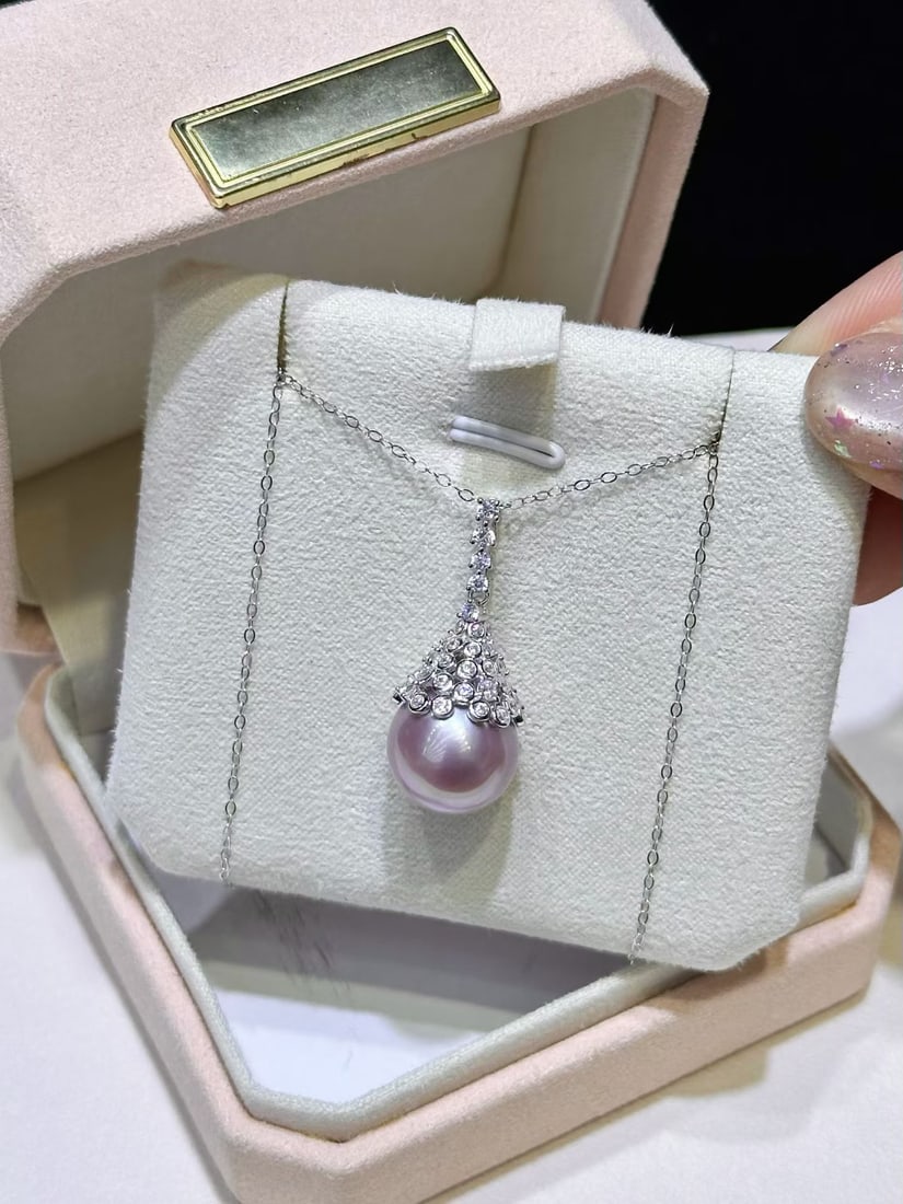 Sterling Silver Edison Pearl Pendant: This pendant is meticulously crafted in sterling silver, featuring a 12-13mm Edison pearl that showcases its strong luster and natural slight blemishes. The round shape of the pearl complements the si
