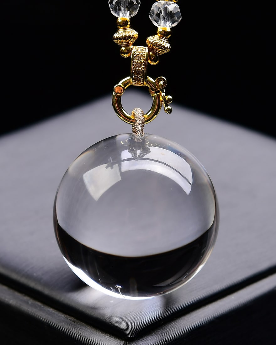 Natural White Crystal Pendant: This natural white crystal pendant features a flawless and pure crystal, showcasing its pristine beauty. The rounded shape symbolizes completeness and smoothness, making it a collectible piece of art.