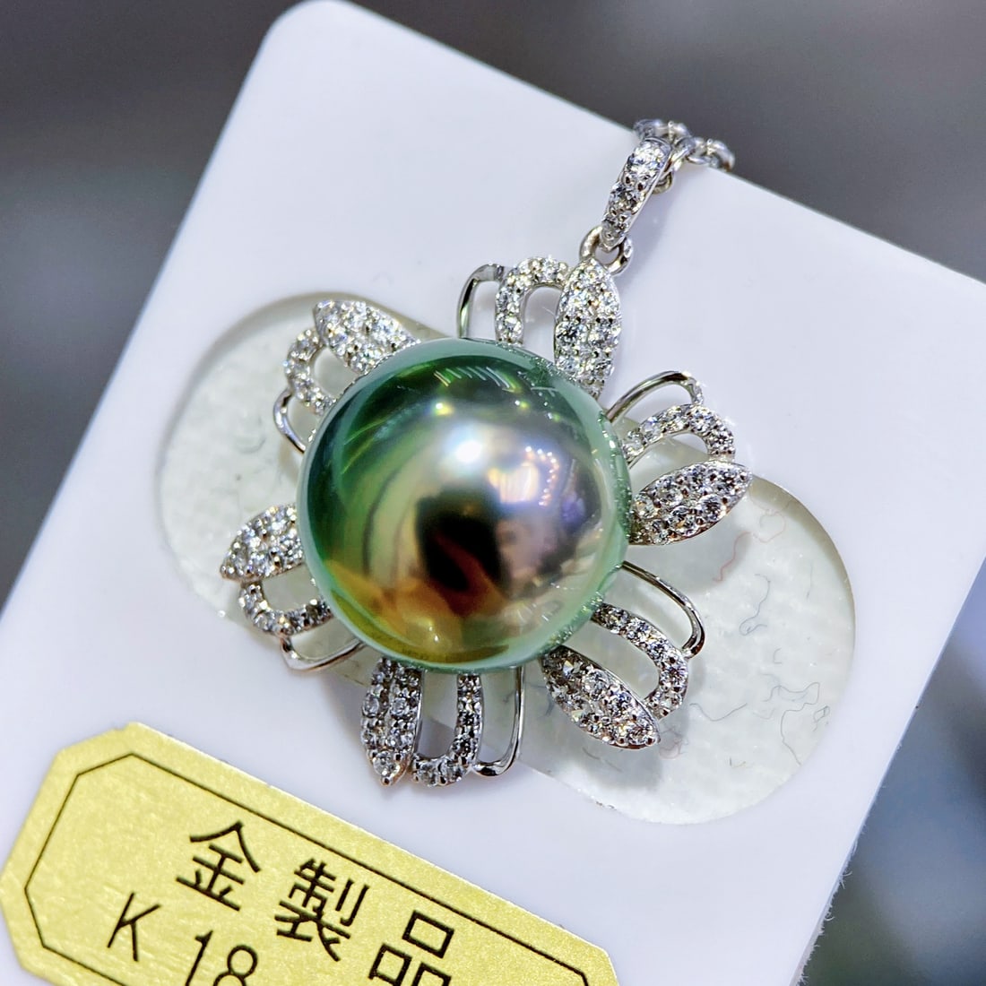 18K White Gold Flawless Peacock Green Pearl Pendant: This pearl pendant showcases a flawless peacock green hue, exuding a noble and elegant aura. The 18K white gold material perfectly complements the pearl, with a floral setting adding a touch of intell