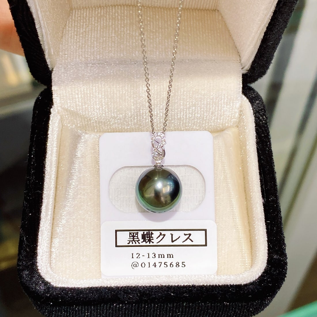 18K Gold Tahitian Pearl Pendant: This pendant features an 18K white gold setting with a 12mm Tahitian pearl, showcasing an ink-like rich green luster. The pearl's high quality is nearly flawless, and its perfect round shape enhances 
