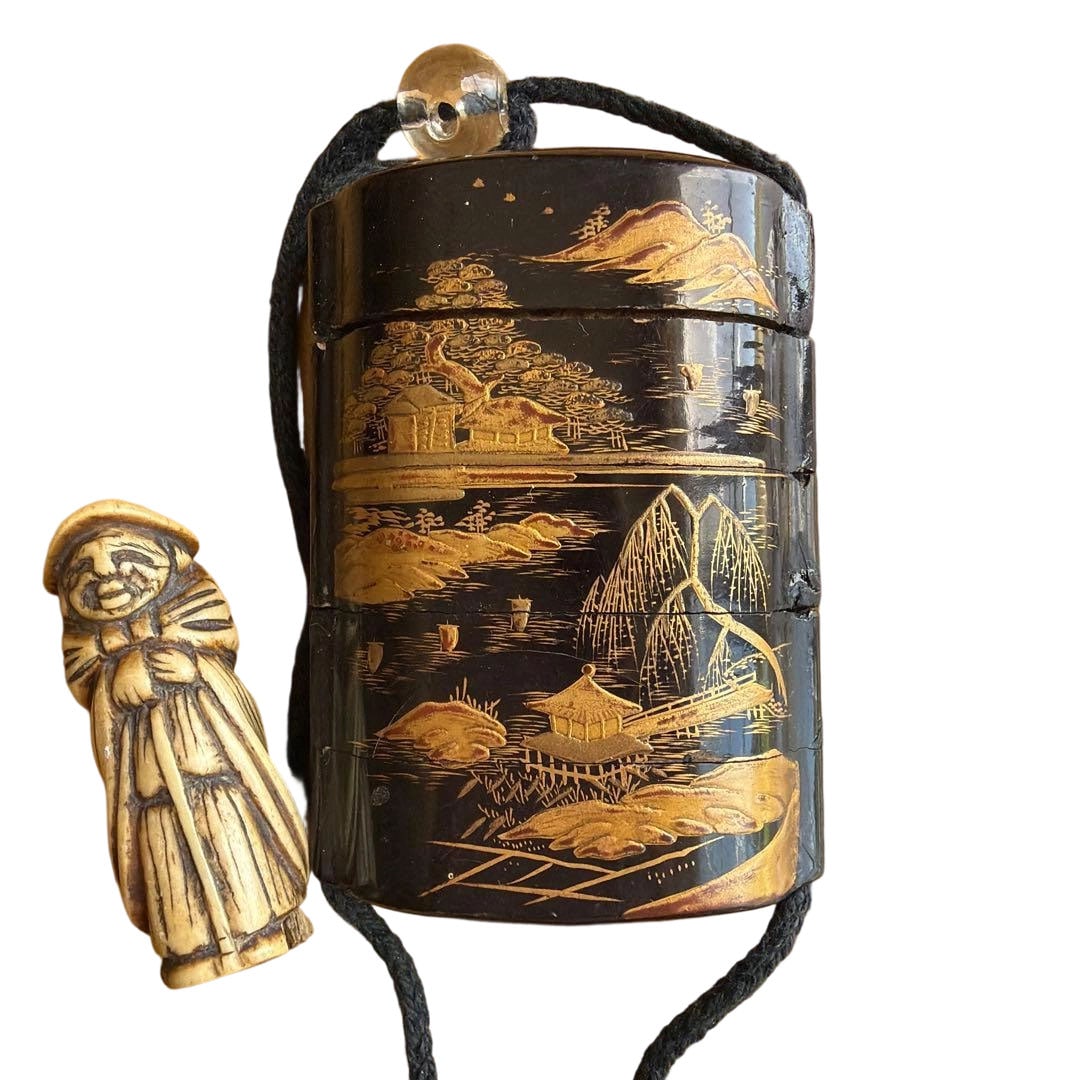 Inro, Makie, Antique Item: Inro with Maki-e Antique A multi-section inro intricately decorated with landscape paintings in gold maki-e on a black lacquer ground, accompanied by a netsuke carved with figures. Type: Inro Decorati