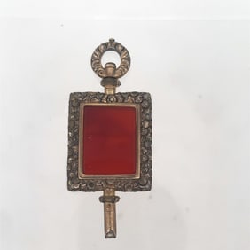 ANTIQUE GILT SILVER REPOUSSE WATCH KEY WITH CARNELION STONE, CIRCA 1860