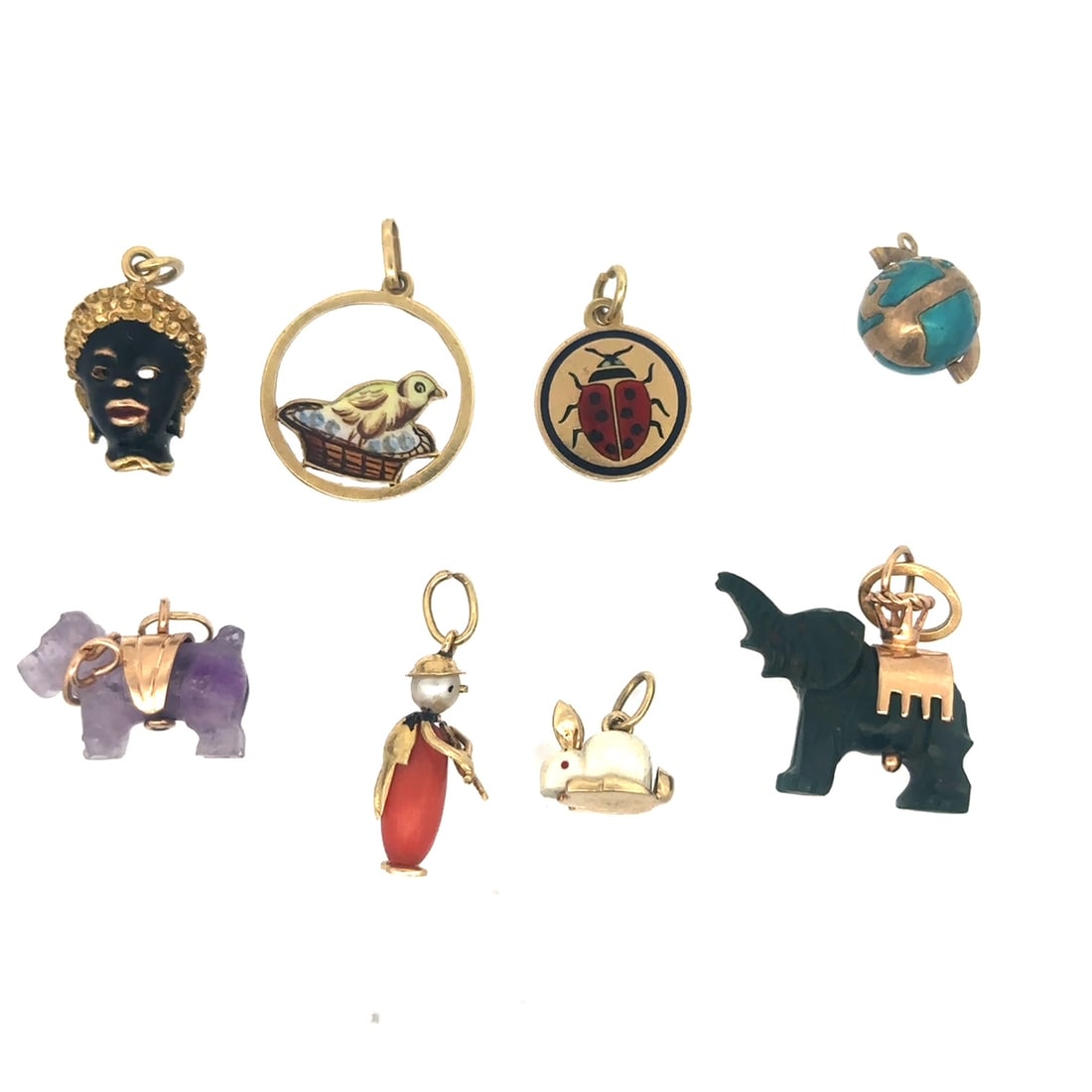 LOT OF 8 VINTAGE 18K GOLD STONE AND ENAMEL CHARMS: Lot of 8 vintage gold charms consisting of an 18k yellow gold and enamel blackamoor, an 18k disc charm with an enameled ladybug, 18k enameled bird sitting in a woven basket, and enameled spinning glob