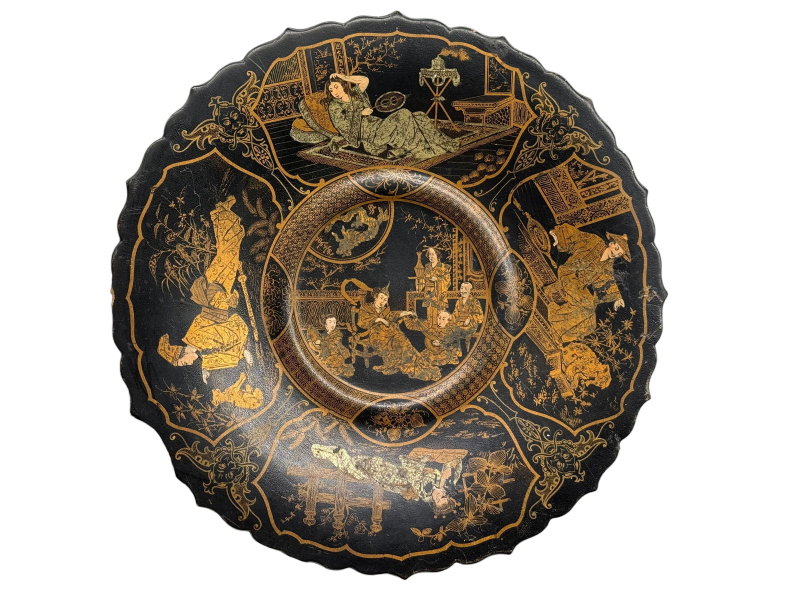 A Japanese Lacquer Dish: Of circular scalloped form, decorated in gilt on a black ground with figural scenes and architectural elements within shaped reserves. D: 11 1/4 inches