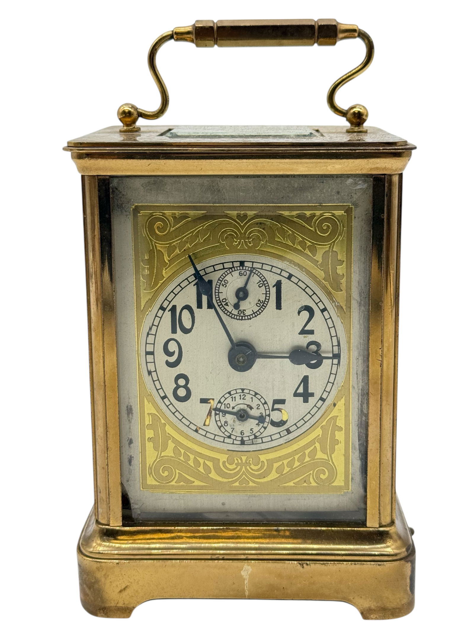 A Brass Carriage Clock: The rectangular case with swing handle, fitted with a white dial with Arabic numerals and subsidiary dials, enclosed by glazed panels. H: 6 inches W: 4 inchesD: 3 3/4 inches