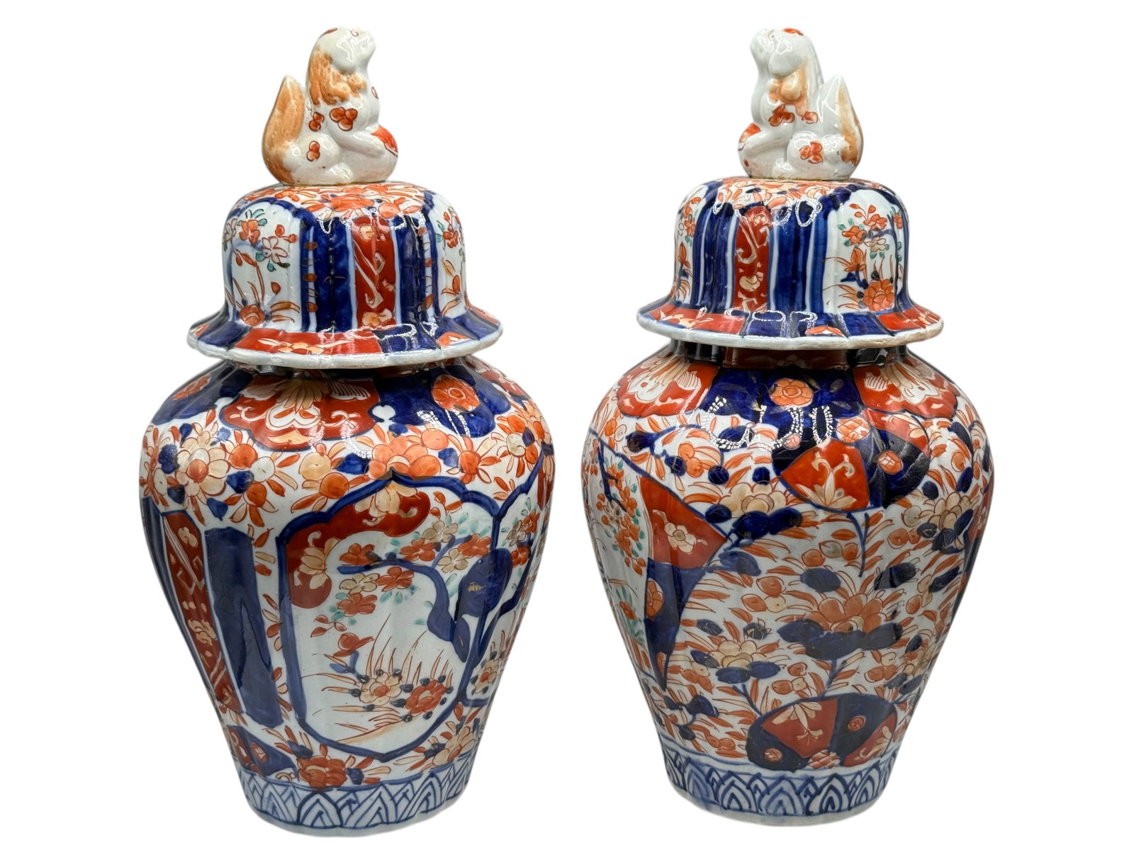 A Pair of Japanese Imari Vases and Covers, Meiji P: Each baluster vase painted with floral panels and geometric reserves in underglaze blue and iron-red, the covers surmounted by bird finials. H: 11 1/2 inches W: 6 inches