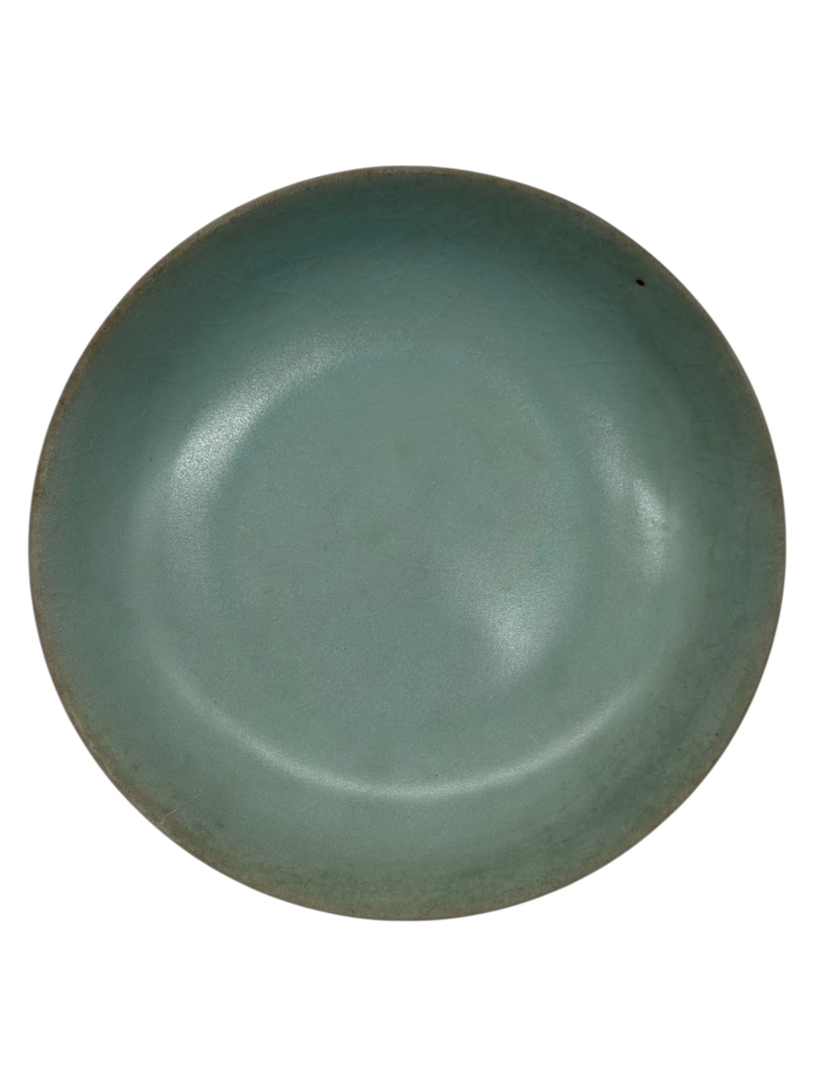 A Chinese Celadon-Glazed Dish: Of shallow circular form, covered in a pale celadon glaze with fine crackle visible throughout. H: 1 3/4 inches W: 7 1/4 inches