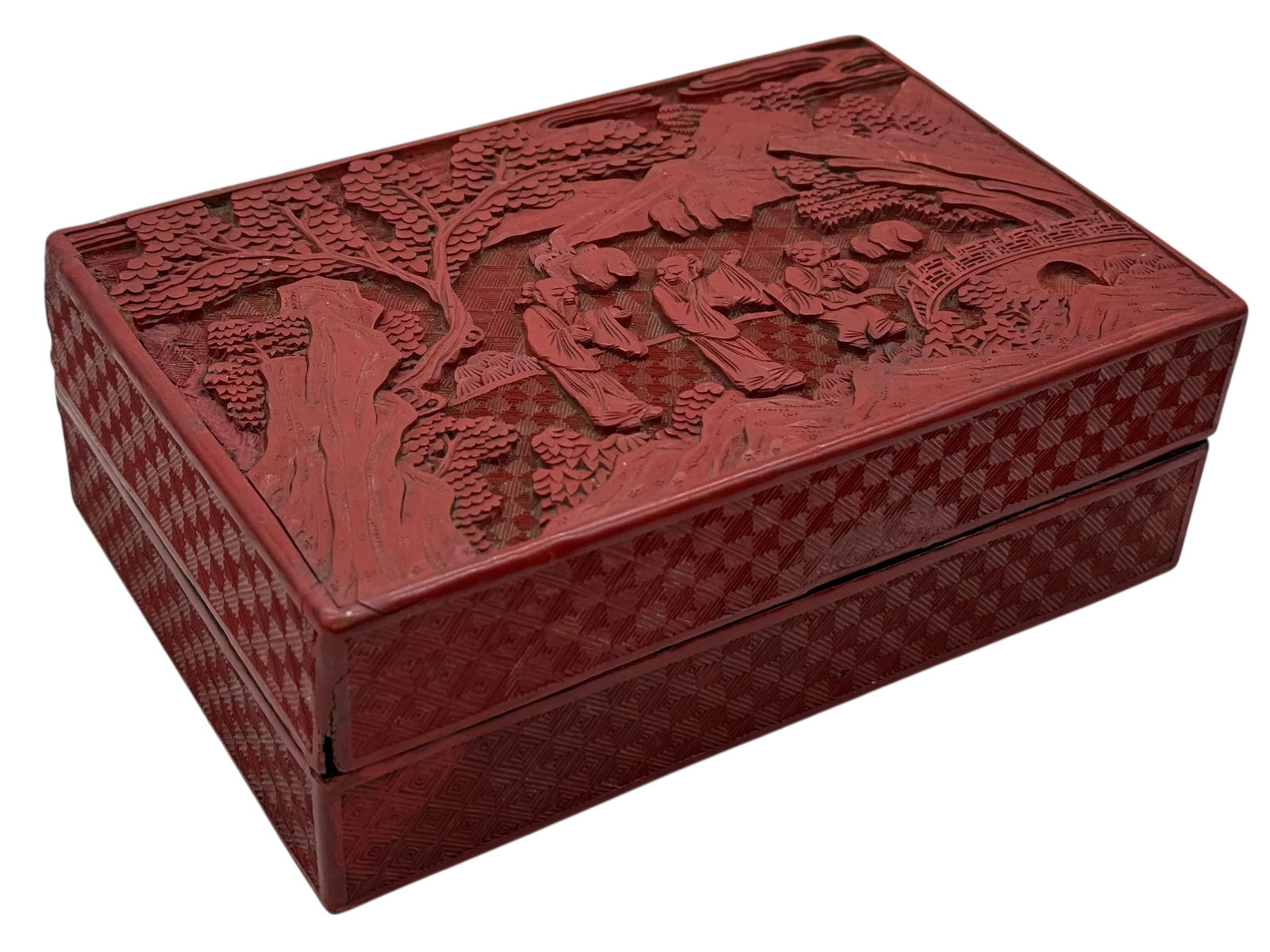 A Chinese Carved Red Lacquer Box and Cover: A Chinese Carved Red Lacquer Box and CoverA Chinese Carved Red Lacquer Box and Cover, the top carved with figures in a landscape, the sides with diaper pattern. H: 2 1/2 inches W: 7 1/4 inchesD: 4 3/4