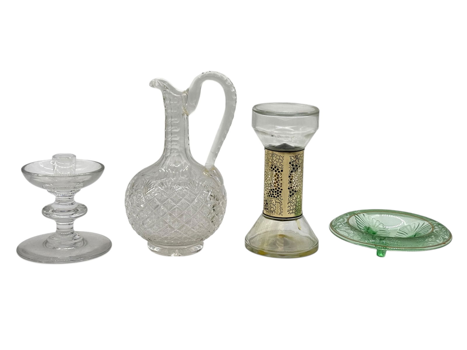 A Group of Decorative Glassware Pieces: A Group of Decorative Glassware PiecesA small mixed group of decorative glassware, including a cut-glass pitcher, a glass candlestick, a perforated metal-mounted glass vessel, and a green