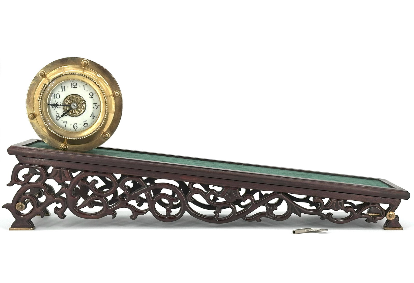 A French Brass Ships Clock with Wooden Stand: The circular brass clock with Arabic numeral dial, mounted on a carved hardwood display stand. Size: 9 3/4" * 21 1/4" * 5 1/4"