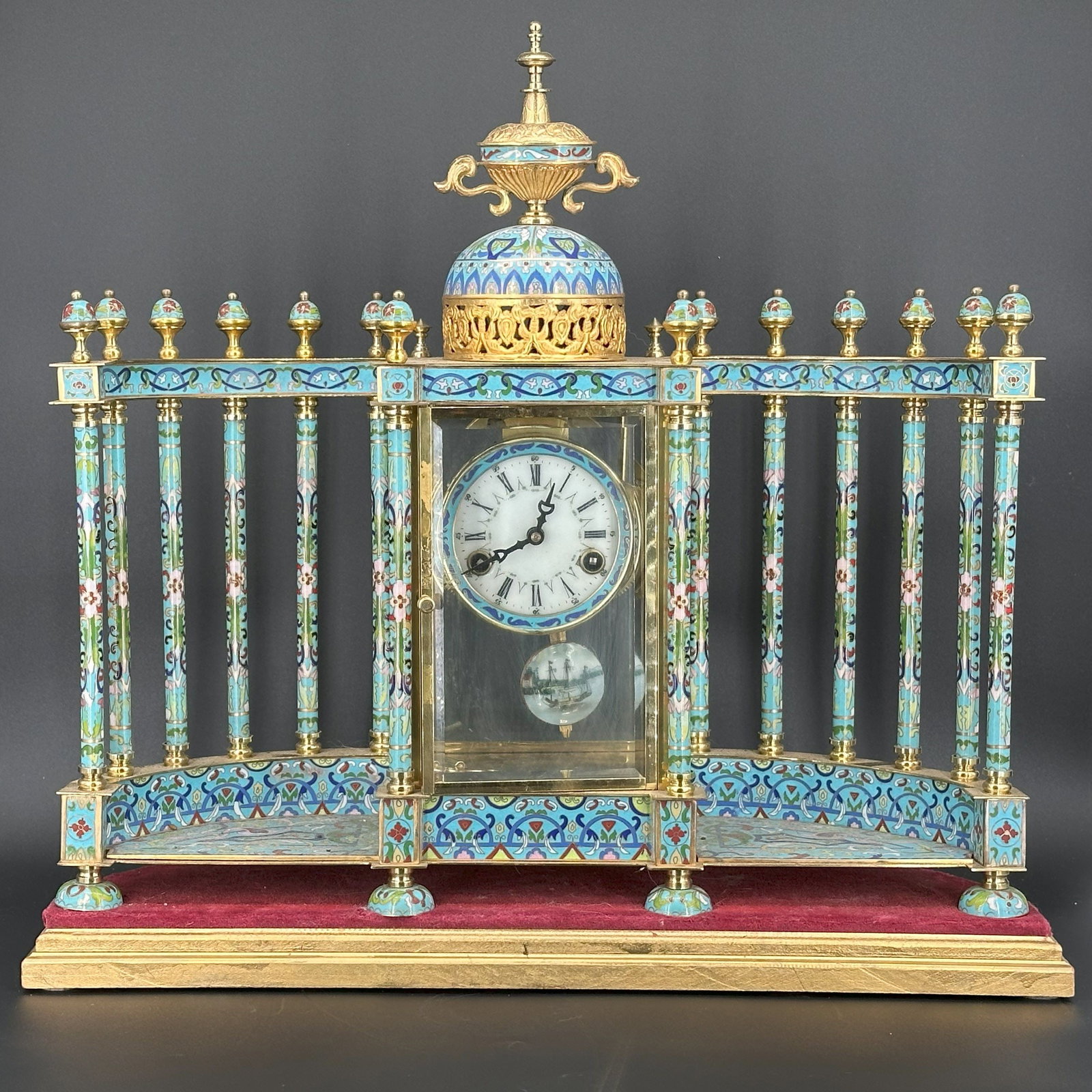 A French Cloisonné Enamel Mantel Clock: The rectangular case with turquoise-ground cloisonné enamel decoration, enclosing a circular enamel dial and pendulum movement. H: 22 1/2 inches L: 20 3/4 inches, 7 inches