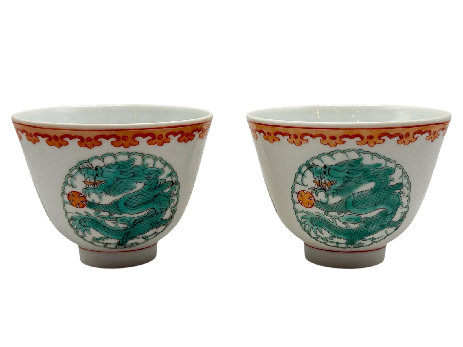 A Pair of Chinese Famille Verte Porcelain Cups: Each of tapering form, painted with a dragon roundel beneath an iron-red and gilt border, the base bearing a four-character mark. H: 2 1/4 inches D: 3 inches