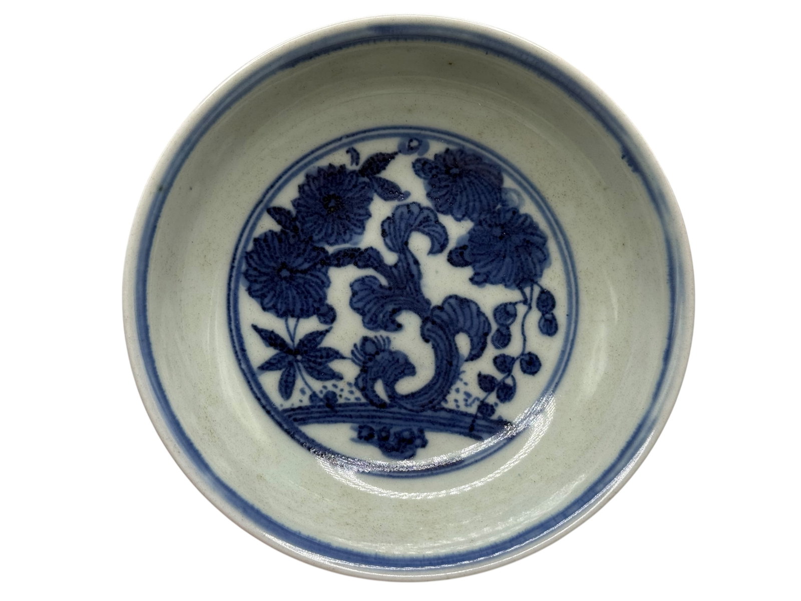 A Chinese Blue and White Porcelain Dish: Decorated to the center with a floral medallion in underglaze blue. H: 1 1/4 inches W: 5 1/2 inches