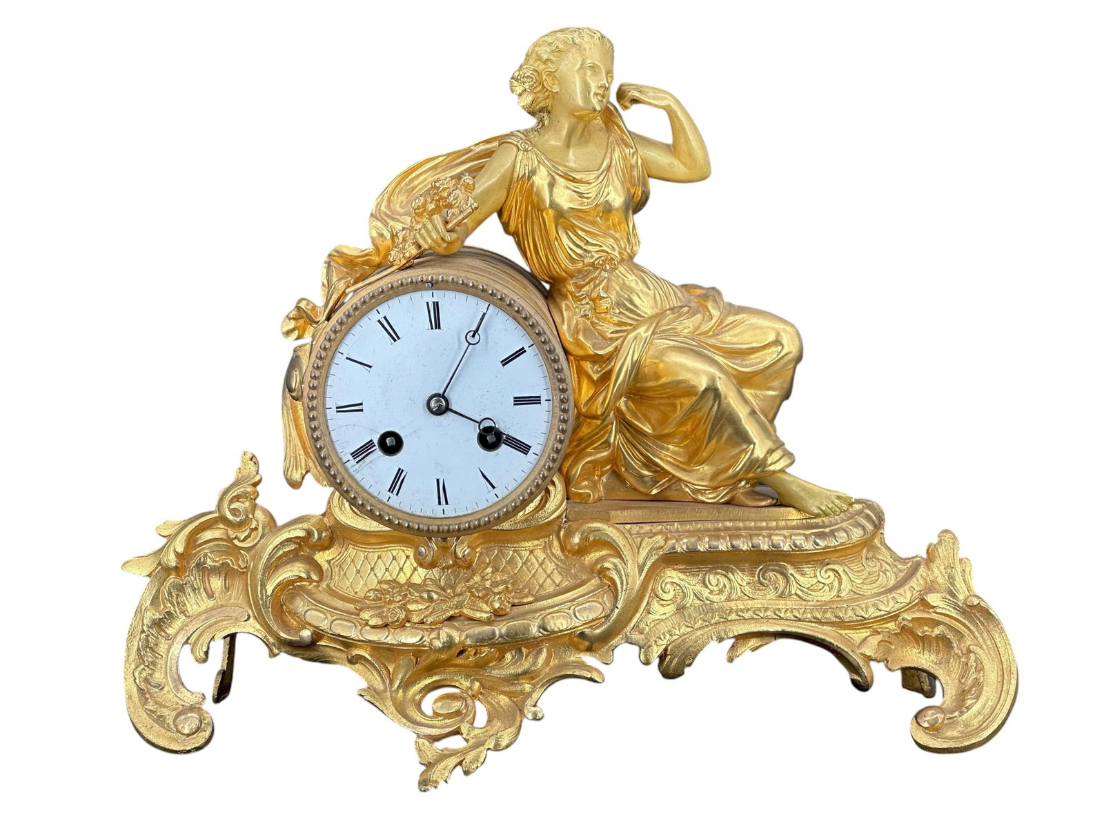A French Gilt Metal Figural Mantel Clock: The circular dial set within a gilt metal case surmounted by a seated classical maiden on a scrolling base Size : 10 1/2" * 13 1/2"* 5 1/2"