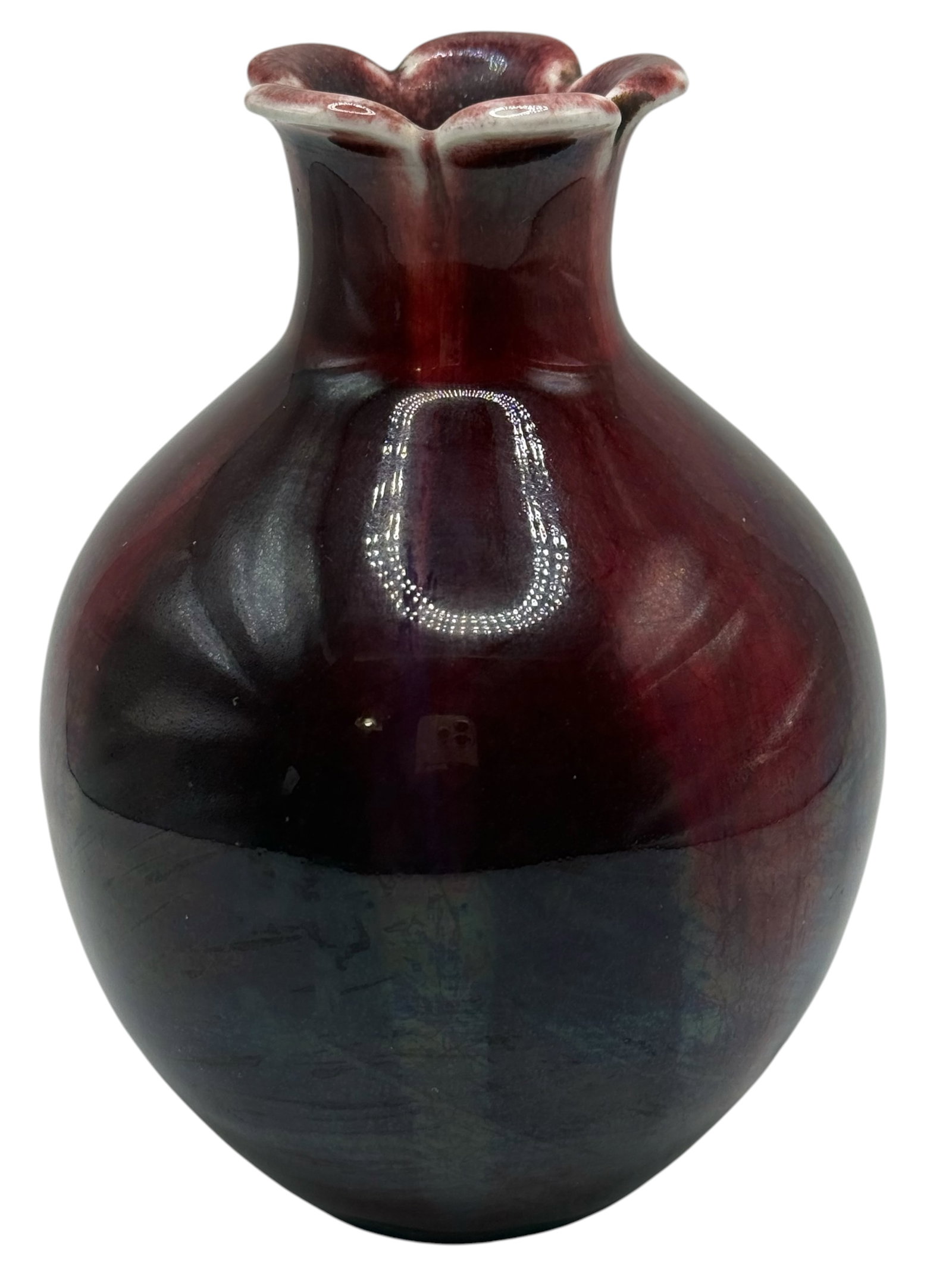 A Chinese Flambé Glazed Porcelain Vase: Globular form with a flared foliate rim, covered overall in a mottled purple and sang-de-boeuf flambé glaze. H: 5 1/2 inches W: 3 3/4 inches