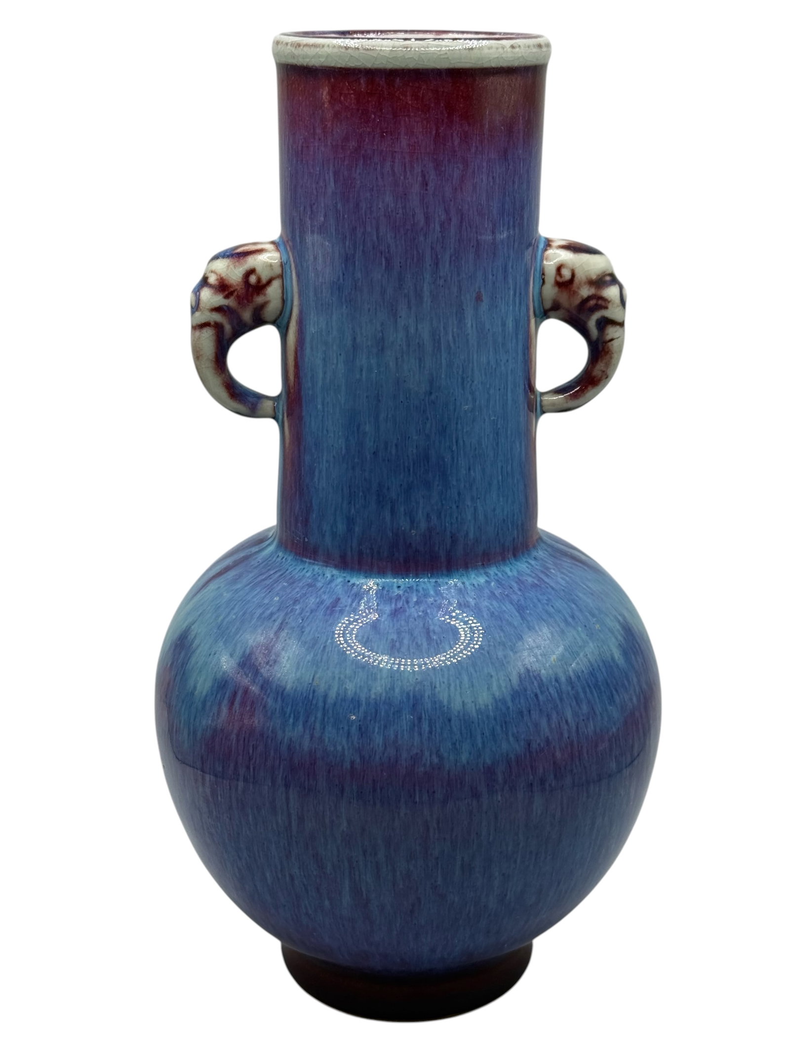 A Chinese Flambé-Glazed Porcelain Vase: Of globular form with tall cylindrical neck and elephant-form handles, covered in a blue and purple glaze, the base with a six-character mark. H: 10 1/2 inches W: 5 1/2 inches