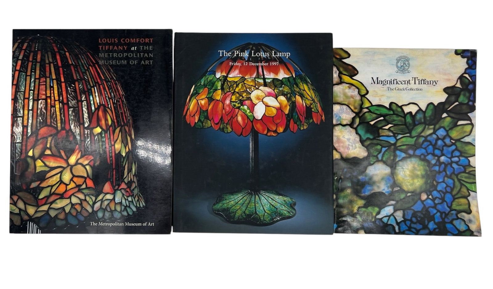 Three Tiffany Reference Books and Auction Catal: Group of Tiffany Reference Books and Auction Catalogues (1) Louis Comfort Tiffany at The Metropolitan Museum of Art.(2) Sotheby's, 1997. The Pink Lotus Lamp. (3) Magnificent Tiffany: The Gluck Collect