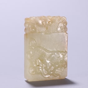 A Qing Dynasty jade lion playing with a ball plaque from Hotan