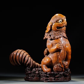 A bamboo carving of a lion playing with a ball incense burner