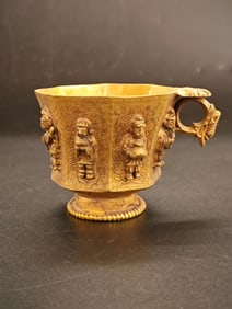 A Tang Dynasty gilded copper figurine with a figure pattern octagonal cup
