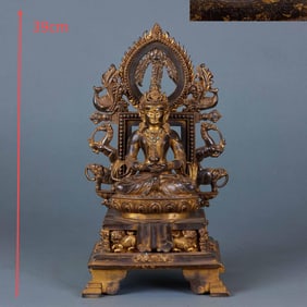 A gilded copper Buddha with a backlit background