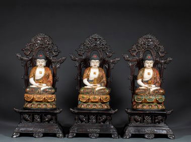A set of Three Buddhas carved from white marble with polychrome details, mounted on a rosewood base