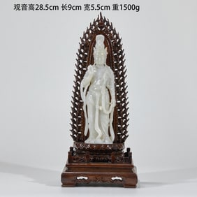A jade-carved Guanyin Bodhisattva figure adorned with ribbons
