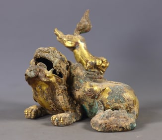 A pair of gilded bronze lion crouching seat ornaments from the Han Dynasty