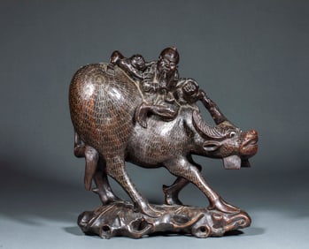 A silver-inlaid rosewood "Cowherd Riding a Cow" decorative piece