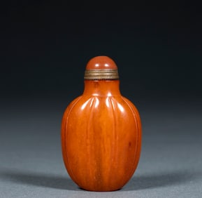 A melon-shaped snuff bottle made of amber