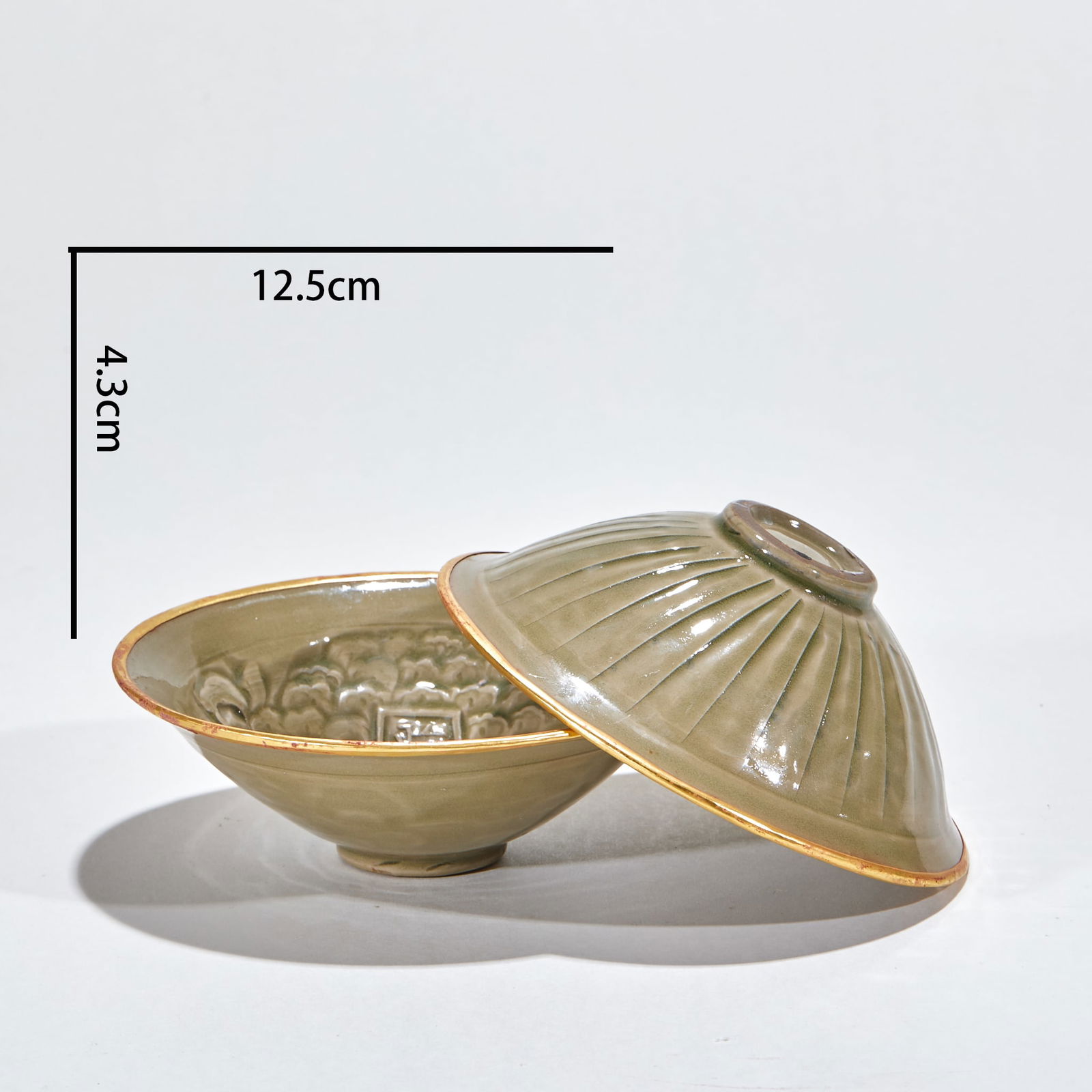 A pair of gold-plated tea cups from the Yaozhou Kiln of the Northern Song Dynasty during the Zhenghe: Northern Song Zhenghe Period Yaozhou Kiln Gold-Clad Tea Cups (a pair), height 4.3cm, diameter 12.5cm. The tea cups are made of Yaozhou Kiln celadon body—a famous Northern Song celadon with a moist g