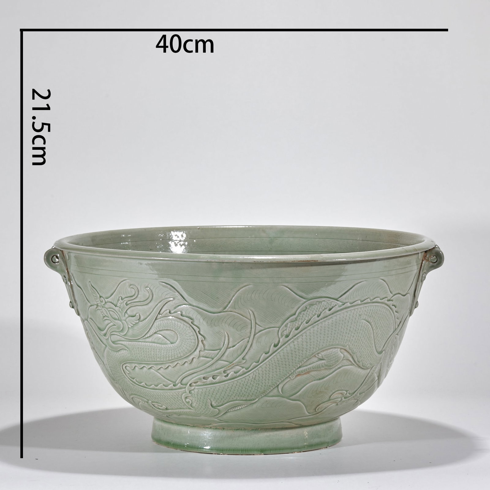 Yue Kiln Basin with Dragon Motifs: Yue Kiln Celadon Basin with Dragon Motifs Made of Yue Kiln celadon with carved craftsmanship, this basin measures 21.5 cm in height and 40 cm in diameter; the body is decorated with an intricate