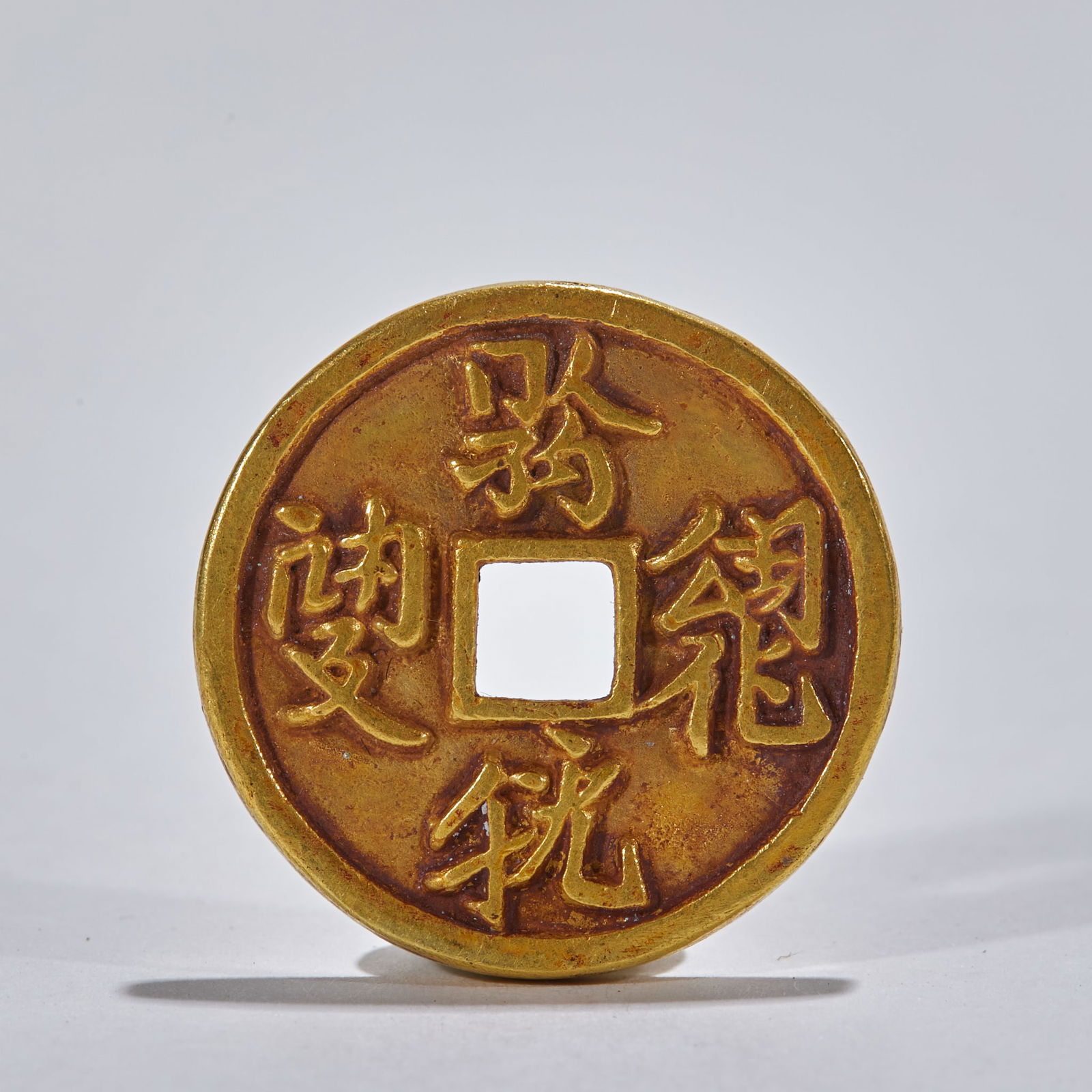 Liao Dynasty Gold Coin with Khitan Script: Liao Dynasty Gold Coin with Khitan Script: Material is pure gold, made into a square-hole gold coin via mould-casting technique and engraved with Khitan script, thickness 0.2cm, diameter 2.6cm,