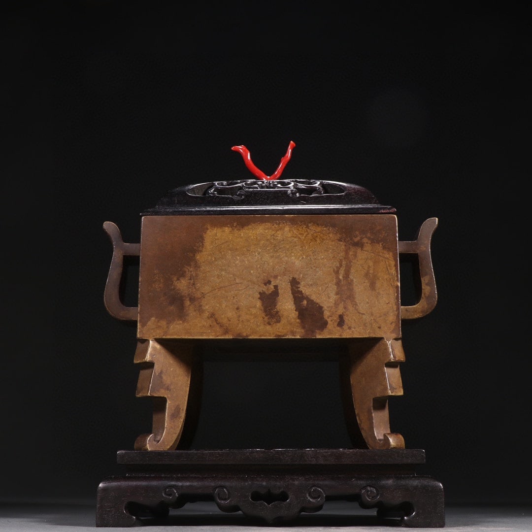 Four-legged Bronze Censer, Chongzhen Mark: Four-Legged Bronze Censer, Chongzhen Mark: Made of copper via lost-wax casting, featuring plain body without patterns, matched with zitan wood openwork furnace cover and base, inlaid with red coral on