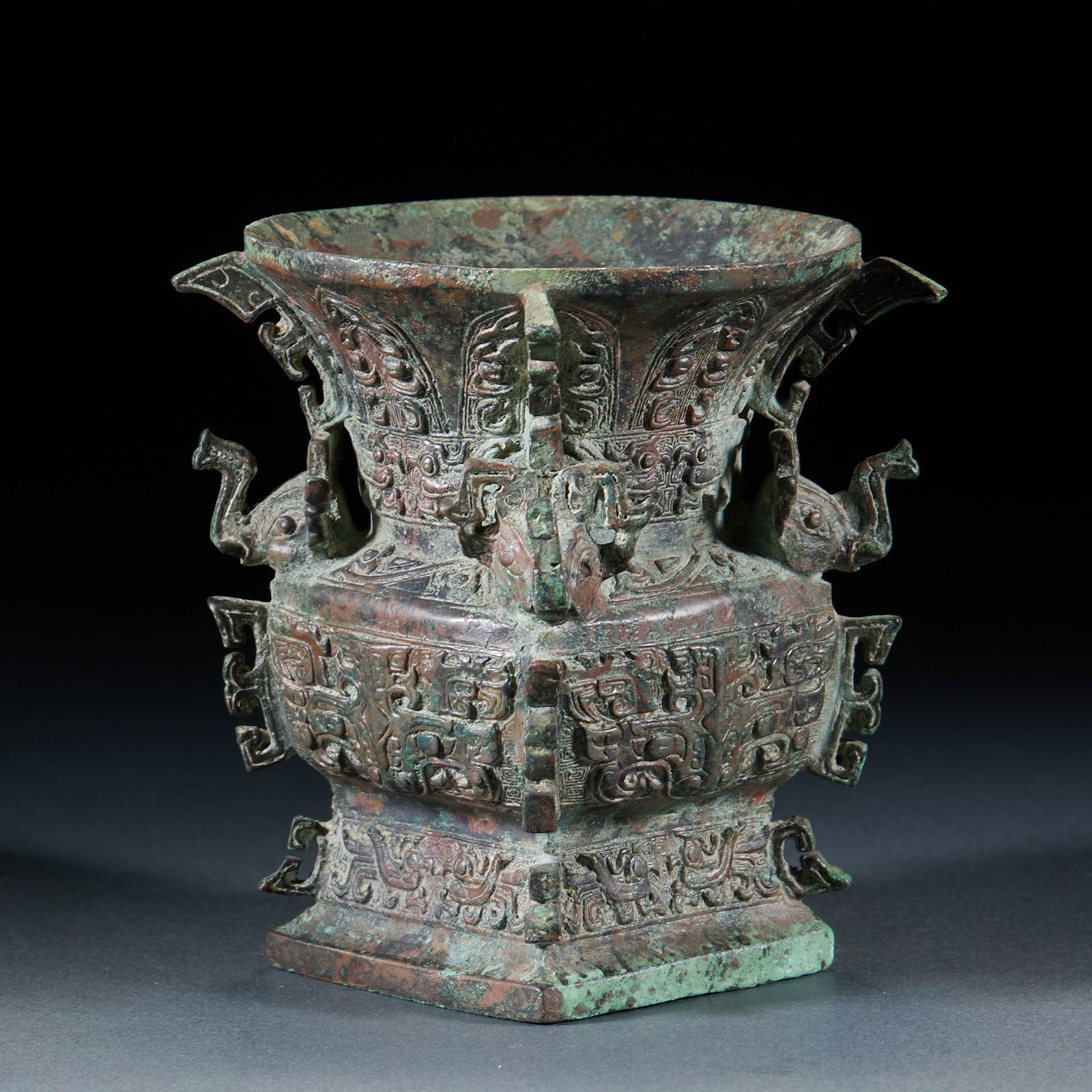 Pre-Ming Bronze Elephant-head Zun with Taotie Pattern: Pre-Ming Bronze Elephant Head Zun with Taotie Pattern: Made of bronze via mold casting, the body is carved with taotie patterns via relief techniques, decorated with elephant head ears on both sides,