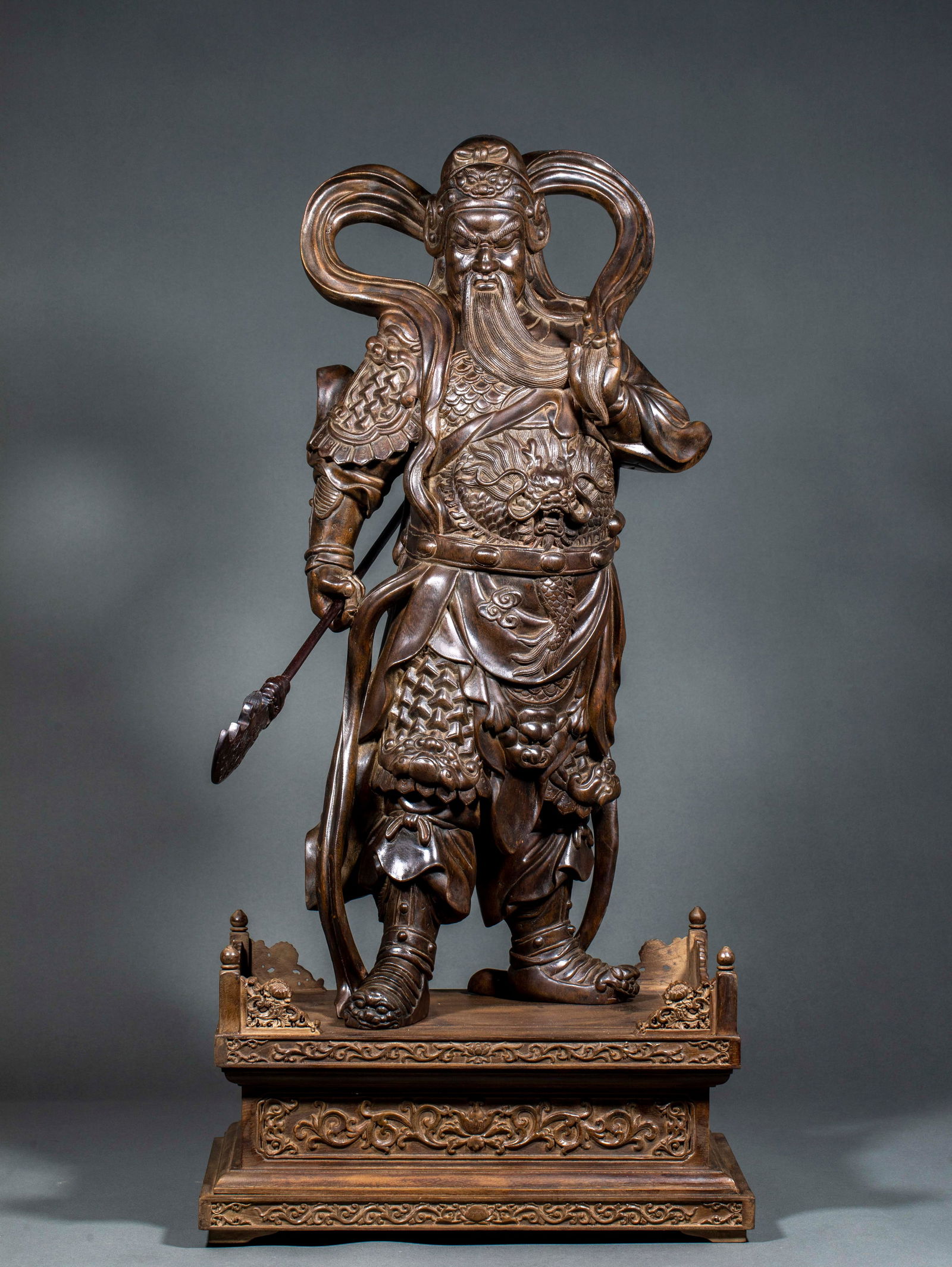Eaglewood Statue of Guan Gong: Agarwood Statue of Guan Gong: Material is precious agarwood, carved into Guan Gong statue via round carving technique, Guan Gong holds a Green Dragon Crescent Blade and stands on a carved base,