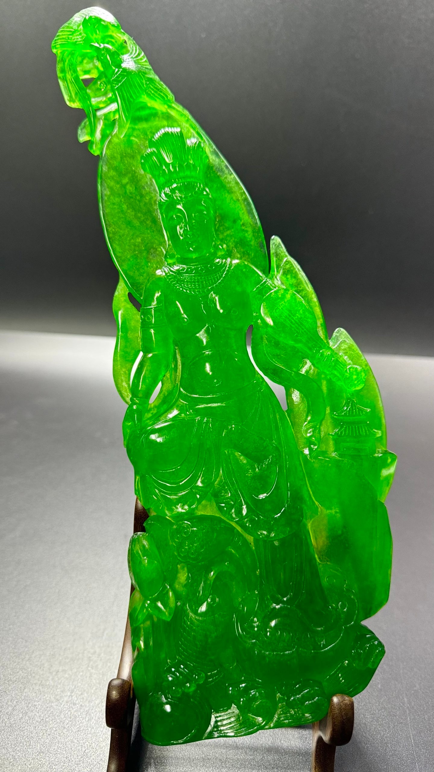 High Ice Jadeite Free Guanyin Statue: High Ice Jadeite Relaxed Guanyin: Material is high ice jadeite, carved into relaxed Guanyin statue via round carving and openwork techniques, transparent texture and rich green color, solemn Dharma