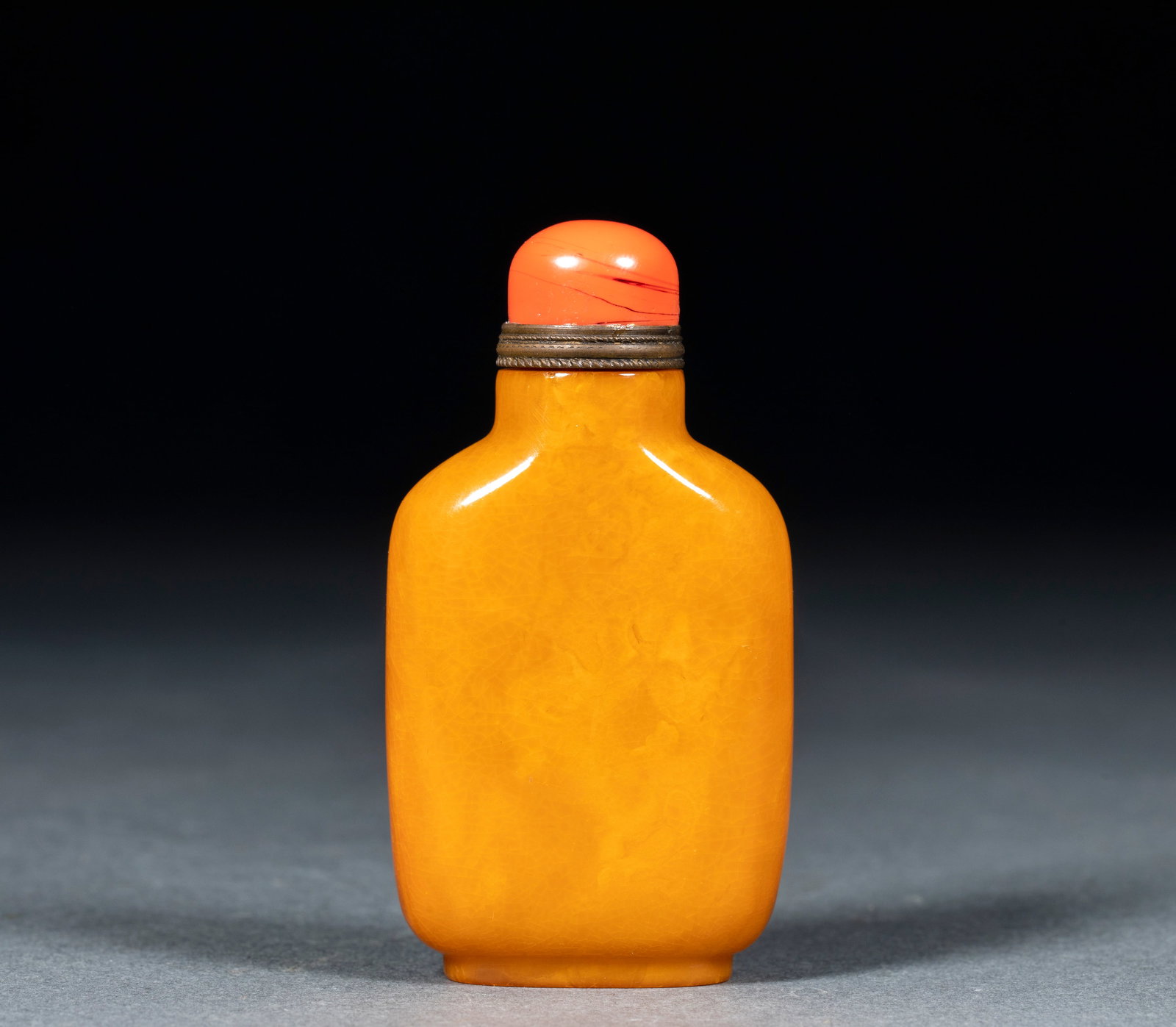 Amber Snuff Bottle: Amber Snuff Bottle: Whole carved amber snuff bottle with red coral lid and metal hoop, regular full shape, warm transparent amber texture and natural grain; specifications: height 7.5cm, length 4cm, w