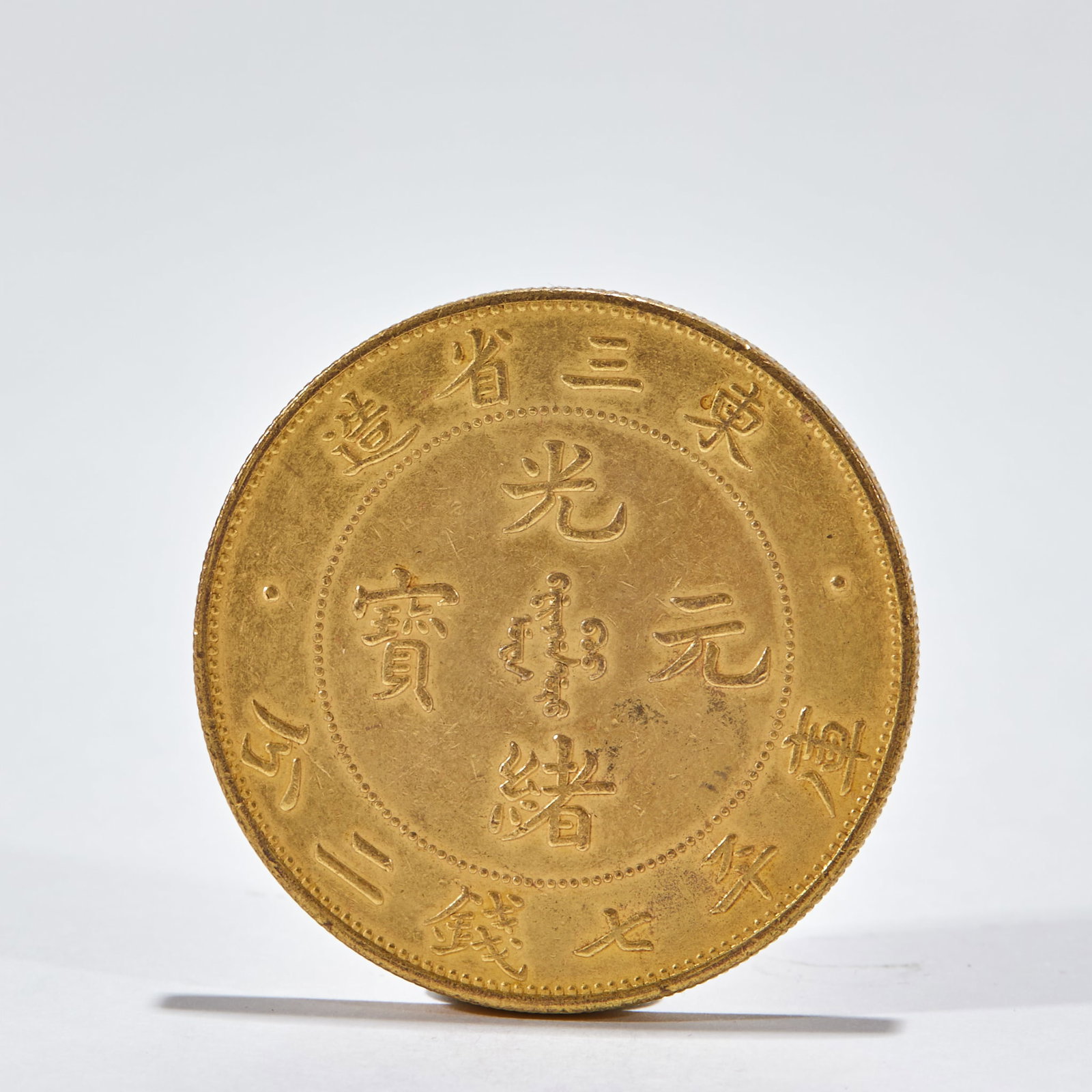 Gilt Silver Guangxu Yuanbao Made in Three Northeast Provinces: Silver Gilt Guangxu Yuanbao Made in Three Eastern Provinces: Cast silver gilt coin inscribed with Guangxu Yuanbao Kuping Seven Mace Two Fen Made in Three Eastern Provinces, well-preserved gilt layer a