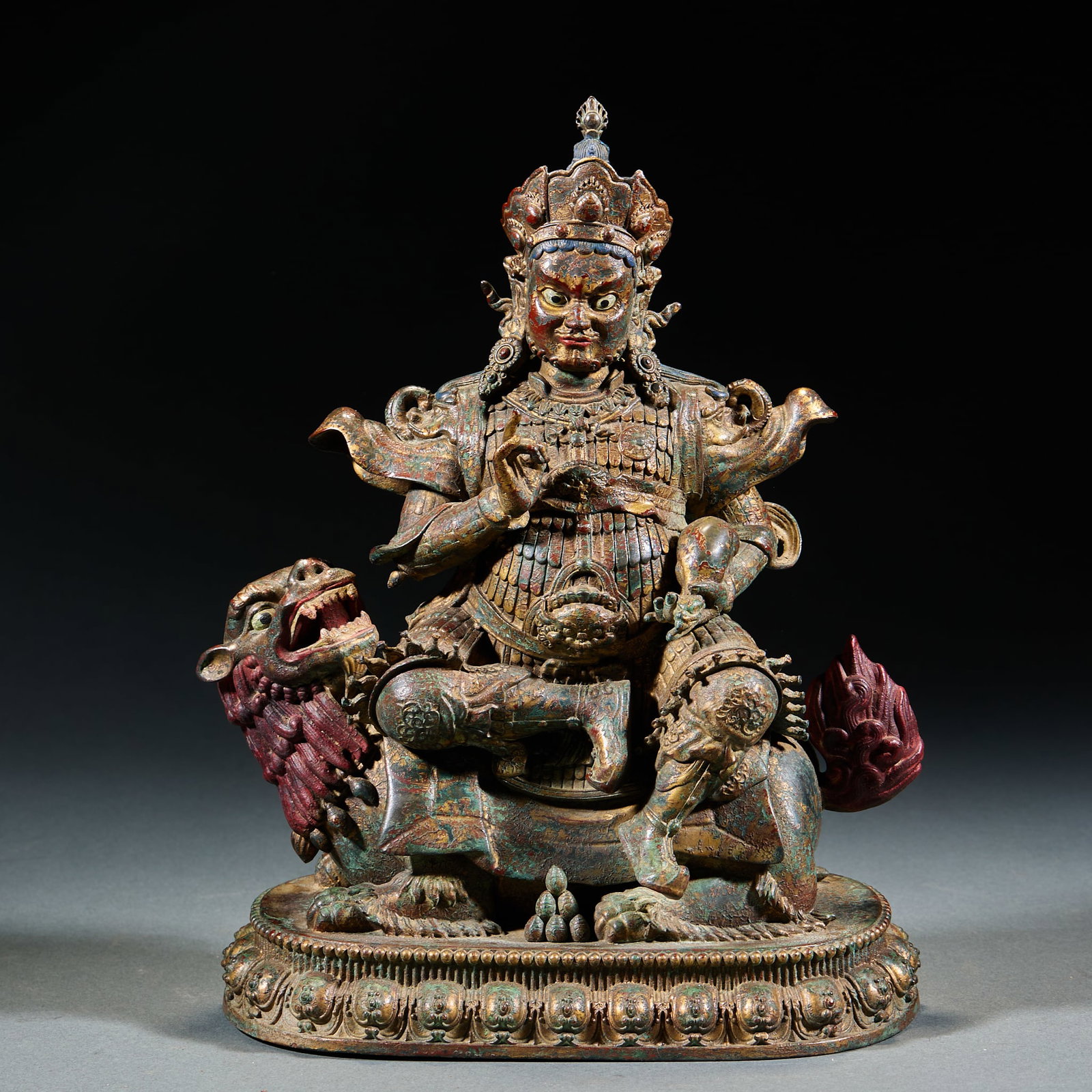 Qing Dynasty Gilt Bronze God of Wealth: Qing Gilt Bronze Jambhala Wealth God: Cast gilt bronze Jambhala seated on lion with treasure crown armor holding ritual implement solemn face vigorous lion, thick lustrous gilt partial color painting