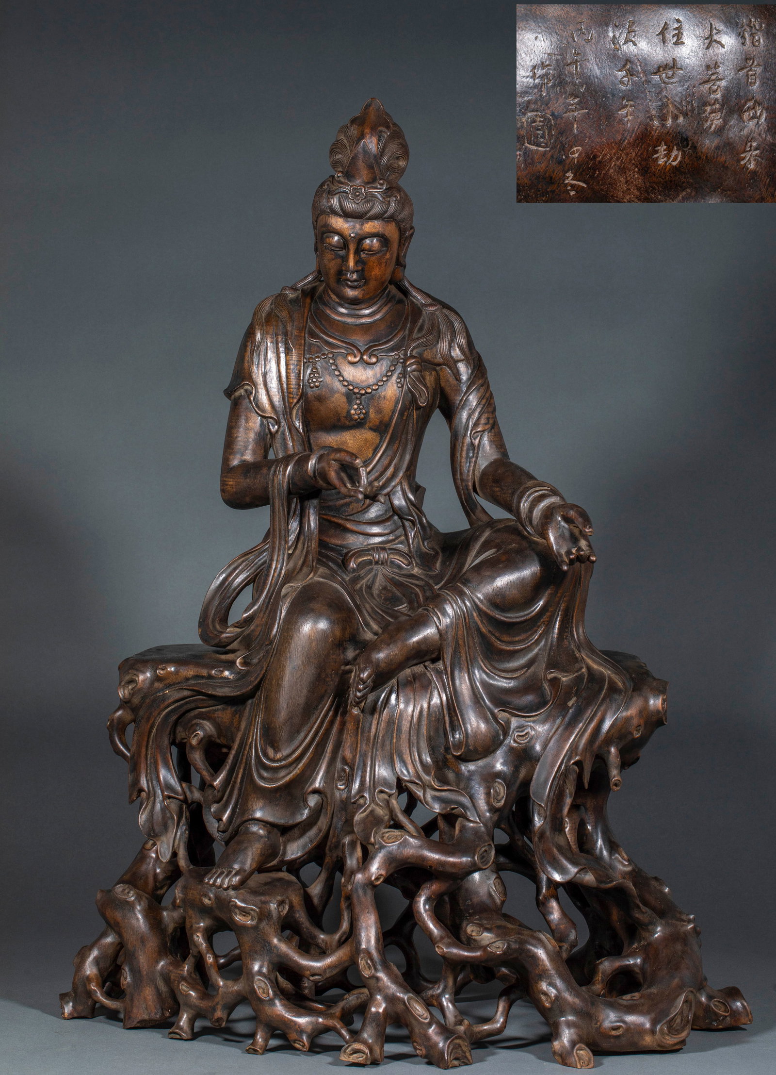 Agarwood Relaxed Guanyin Statue: Agarwood Relaxed Guanyin Statue: Whole round carved agarwood relaxed Guanyin sitting on root base, smooth garment lines merciful face, carved Sutra Inscription, mellow agarwood fragrance;
