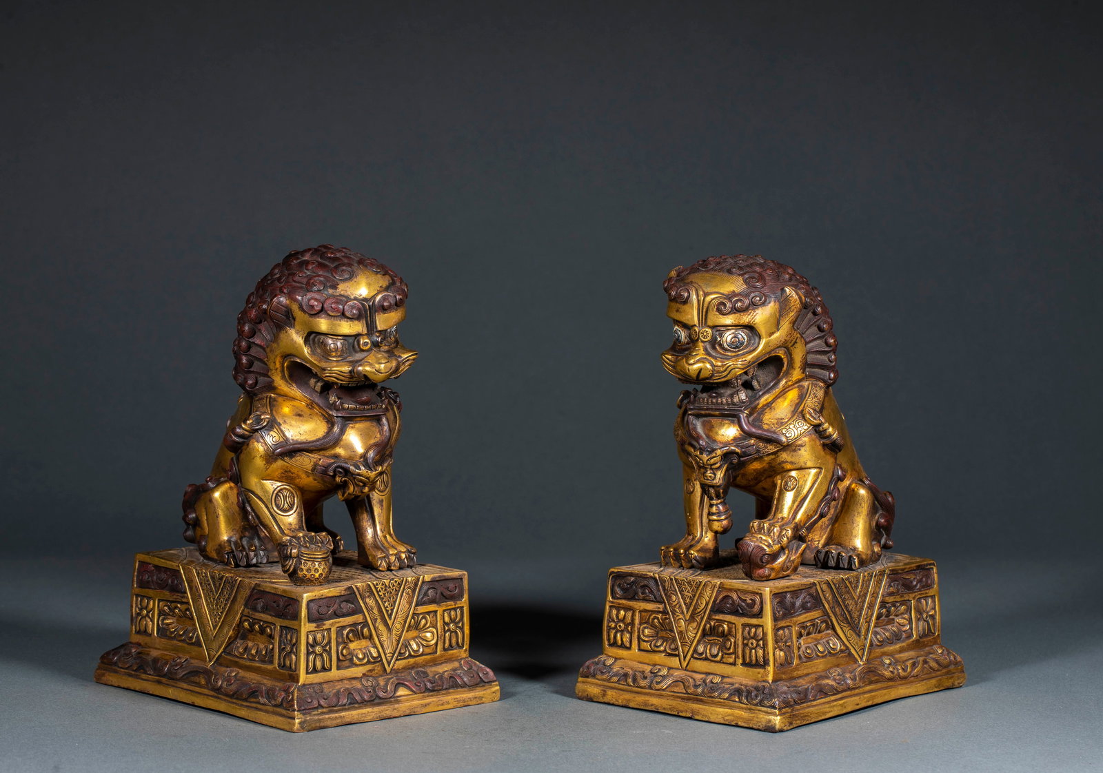 A Pair of Gilt Bronze Suanni: A Pair of Gilt Bronze Suanni: Material is gilt bronze. Round carved as suanni (lion) squatting on square platform, carved with scroll and flower patterns, well preserved in pair. Size: Height 20cm,