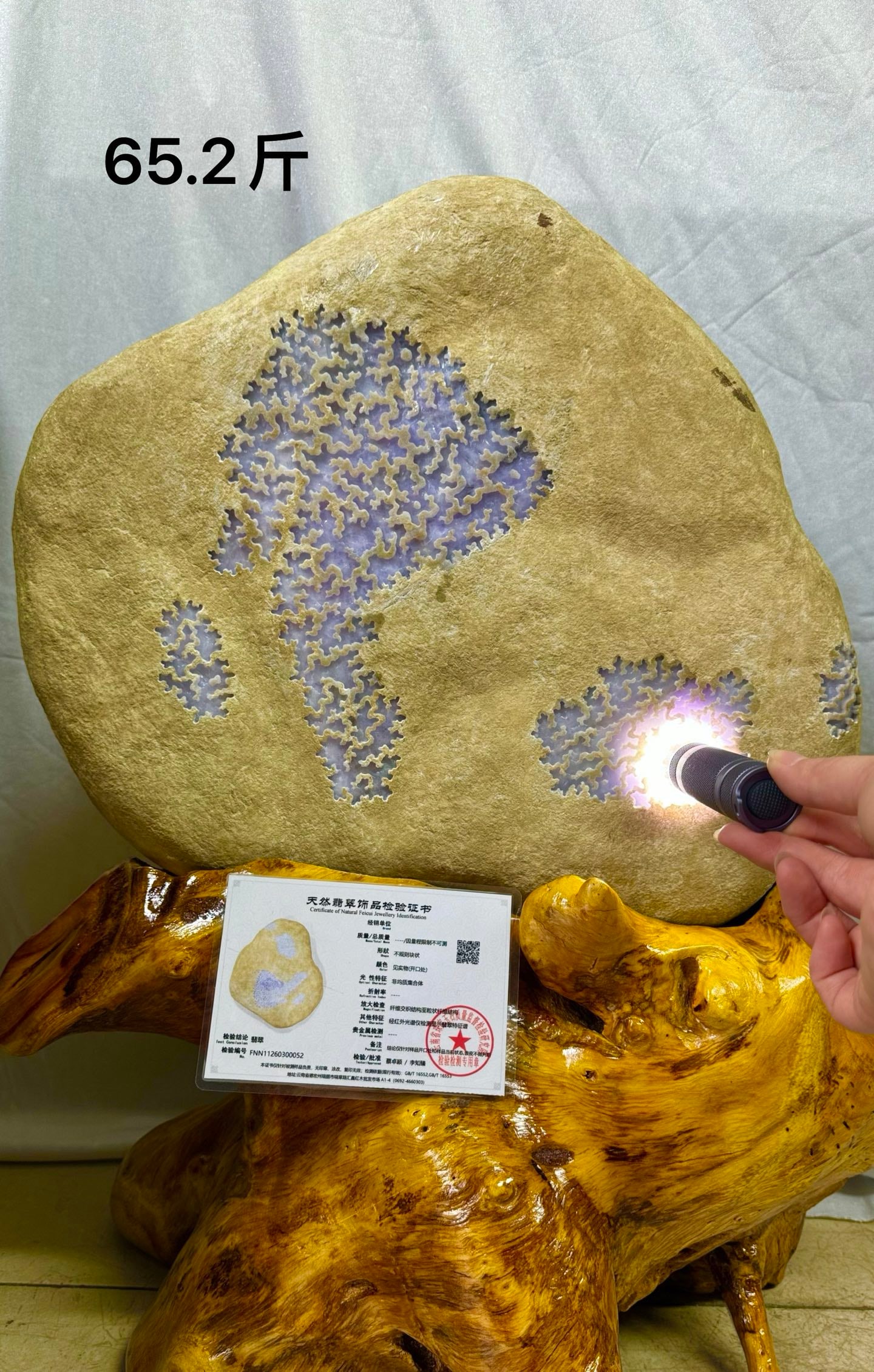 Violet High Ice Jadeite Rough Stone: Violet High-Ice Jadeite Rough Stone: Material is natural jadeite rough stone with natural stone skin, high-ice violet texture at the window, transparent and fine flesh, matched with solid wood base