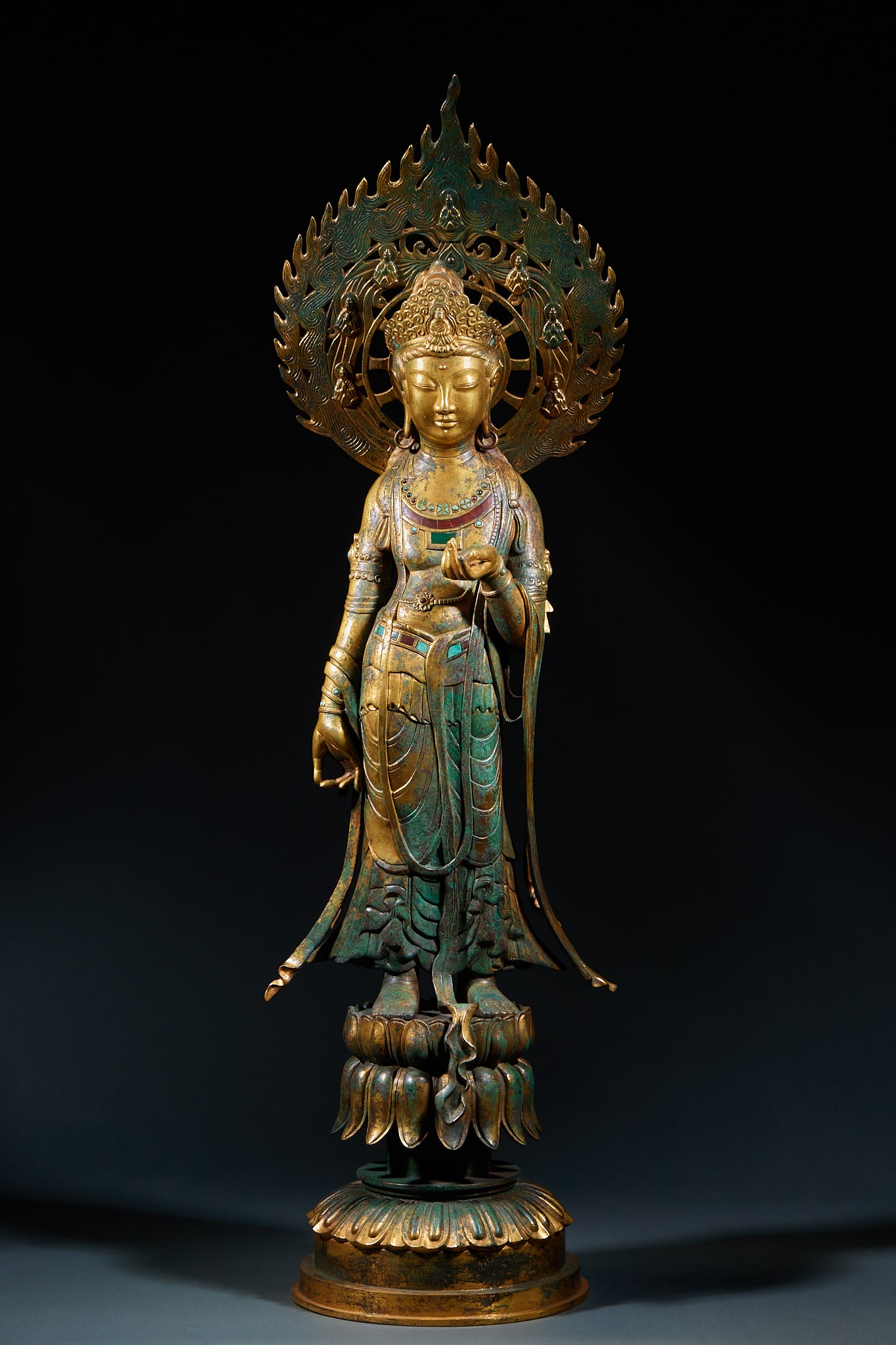 Gilt Bronze Standing Guanyin Statue: Gilt Bronze Standing Guanyin: Crafted of gilt bronze, shaped as a standing Guanyin with gem-inlaid nimbus, solemn Buddhist countenance and full preserved gilding. Specifications: height 79cm, base