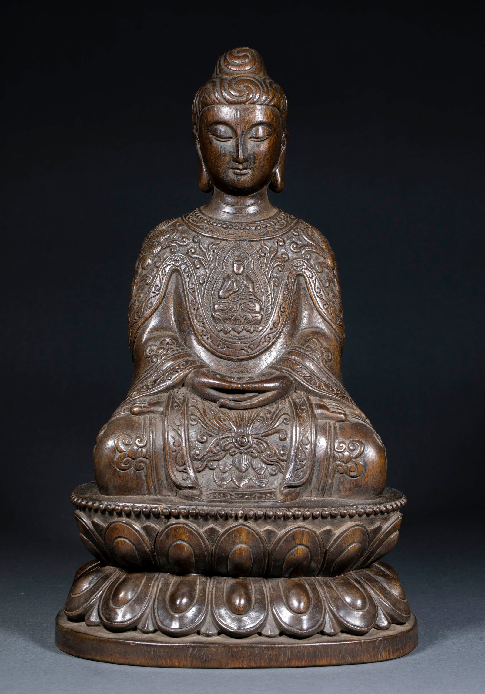 Qing Dynasty Agarwood Seated Buddha Statue: Qing Agarwood Seated Buddha Statue: Round-carved agarwood statue of seated Buddha with flowing robe lines, solemn demeanor and elegant natural agarwood fragrance. Specifications: height 36cm, length 2