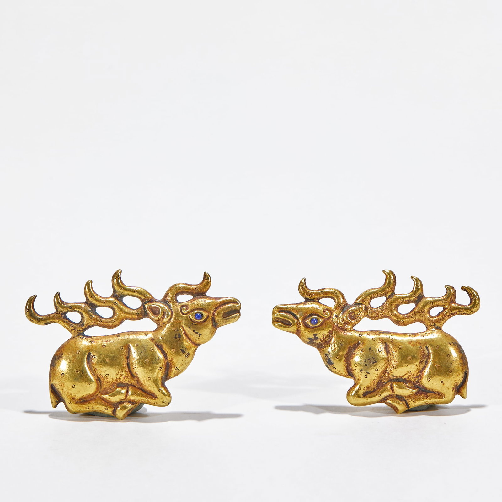 Gilt Silver Deer Pendant, A Pair: Gilt Silver Deer Pendant, A Pair: Gilt silver cast reclining deer shape decorated with gem inlay, preserved as a pair. Specification per piece: length 5.7cm, width 3.9cm, weight 62g. Cultural value: D