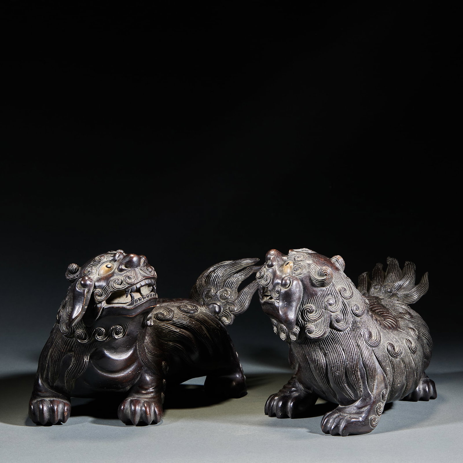 Agarwood Lion Ornament, A Pair: Agarwood Lion Ornament, A Pair: Carved of single natural agarwood log via round and relief carving techniques into lion shape with curled mane, majestic demeanor, smooth lines, delicate wood grain
