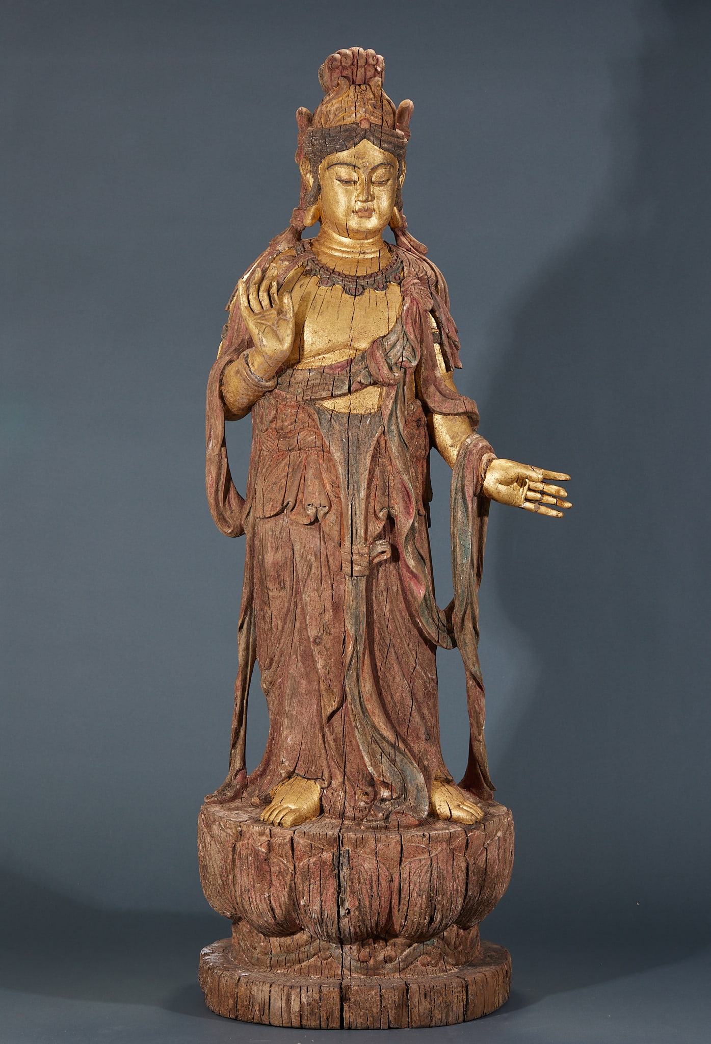 Cypress Wood Guanyin Statue: Cypress Wood Guanyin: Round carved cypress wood statue with dignified facial features, natural flowing robe lines and primitive aged wood patina. Specifications: height 101cm, length 34cm, width