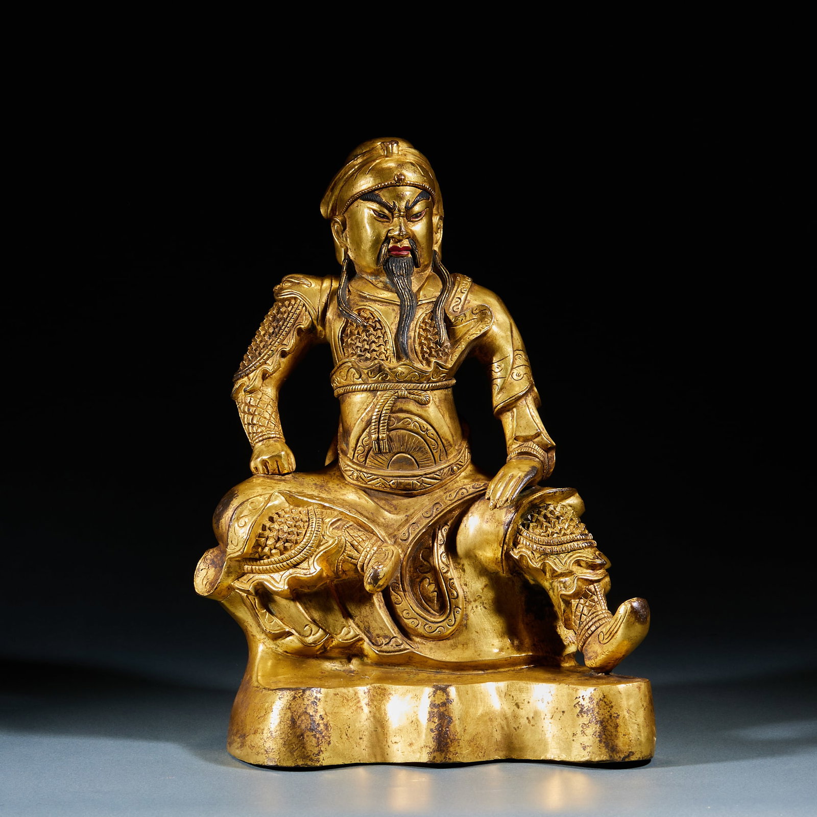 Gilt Bronze Guan Yu Statue: Gilt Bronze Guan Yu Statue: Gilt bronze cast with solemn seated Guan Yu figure, clear armor and robe lines, well preserved gilding. Specifications: height 28.5cm, length 22.5cm, width 12.5cm.